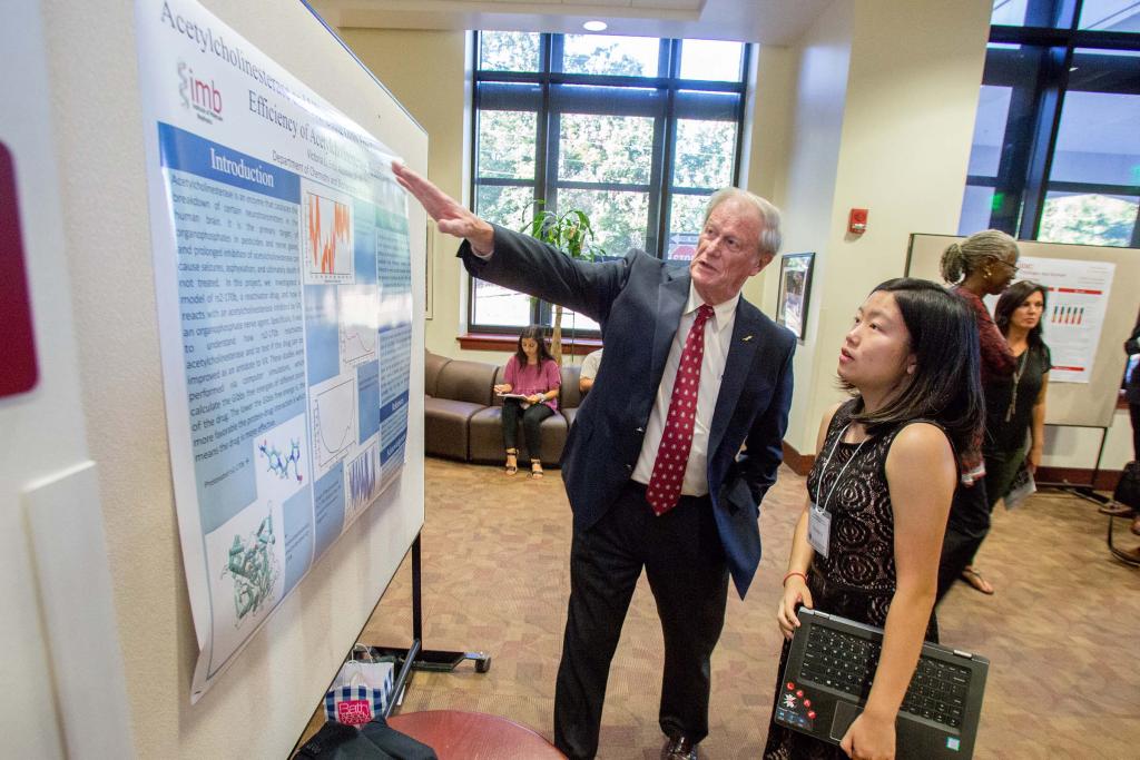 President Thrasher talks with a student during the Undergraduate Research Symposium in October 2018.