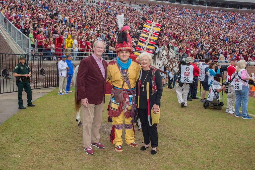 John and Jean Thrasher pose with Kyle Doney of the Seminole Tribe of Florida on the sidelines of the FSU-UF game in November 2018.