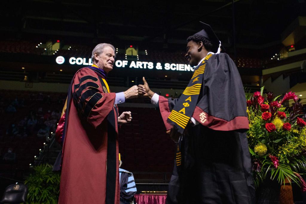 President Thrasher congratulates a graduate during spring commencement in April 2021.