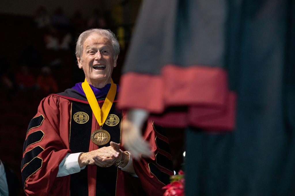 President Thrasher congratulates a graduate during spring commencement in April 2021.