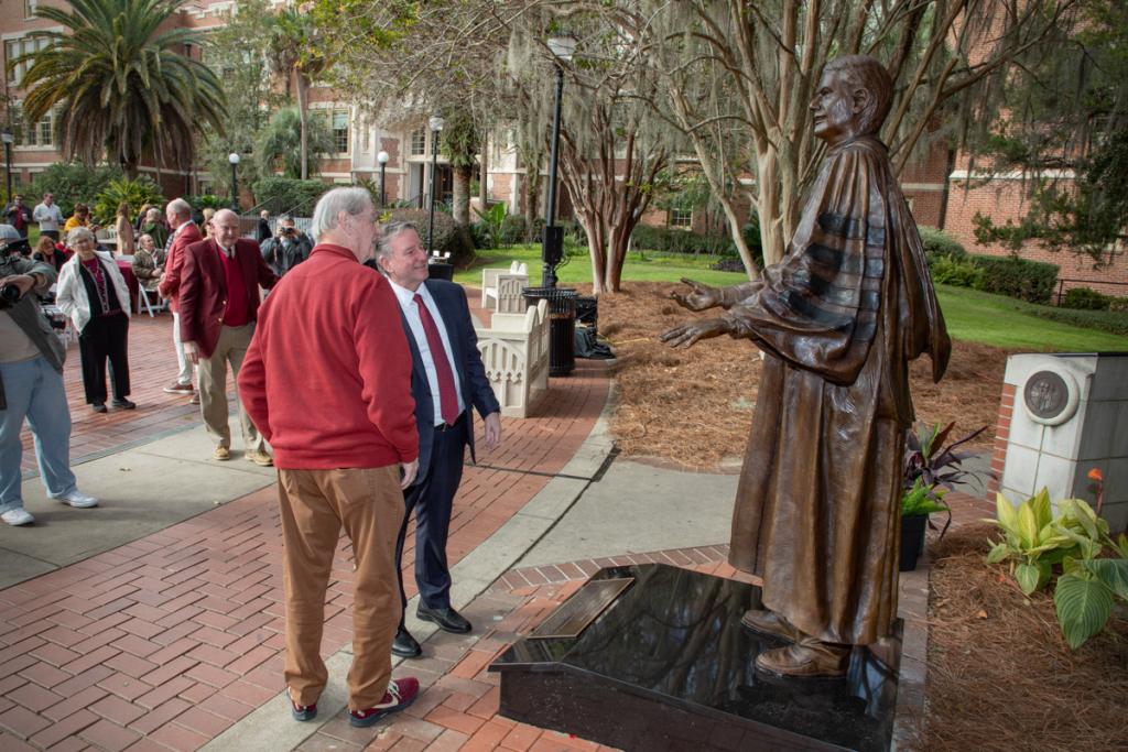 President Richard McCullough and President Emeritus John Thrasher share a moment in front of Thrasher's statue following the dedication ceremony Saturday, Nov. 19, 2022, at Westcott Plaza.